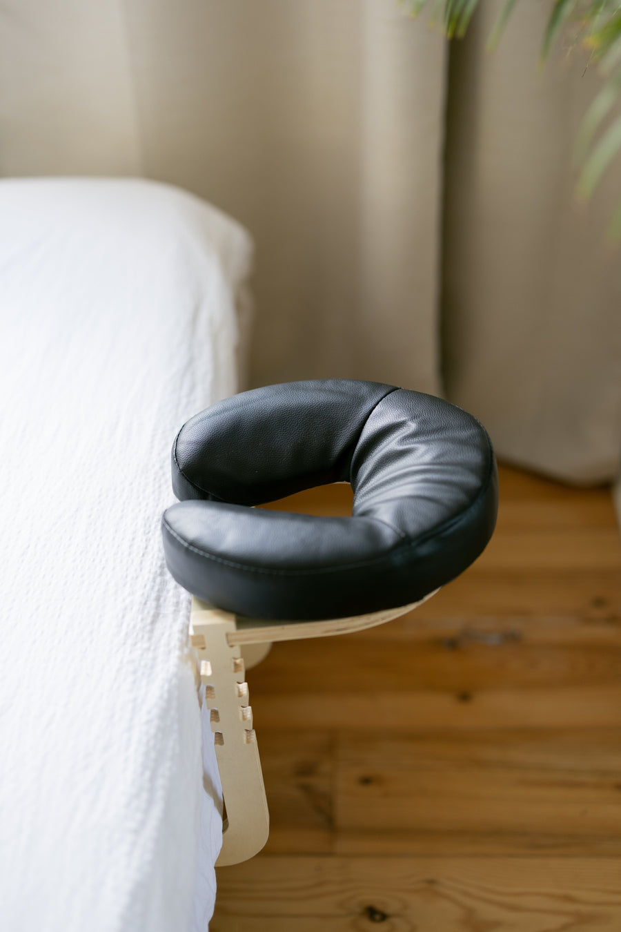The black head cushion on the frame at the edge of a bed