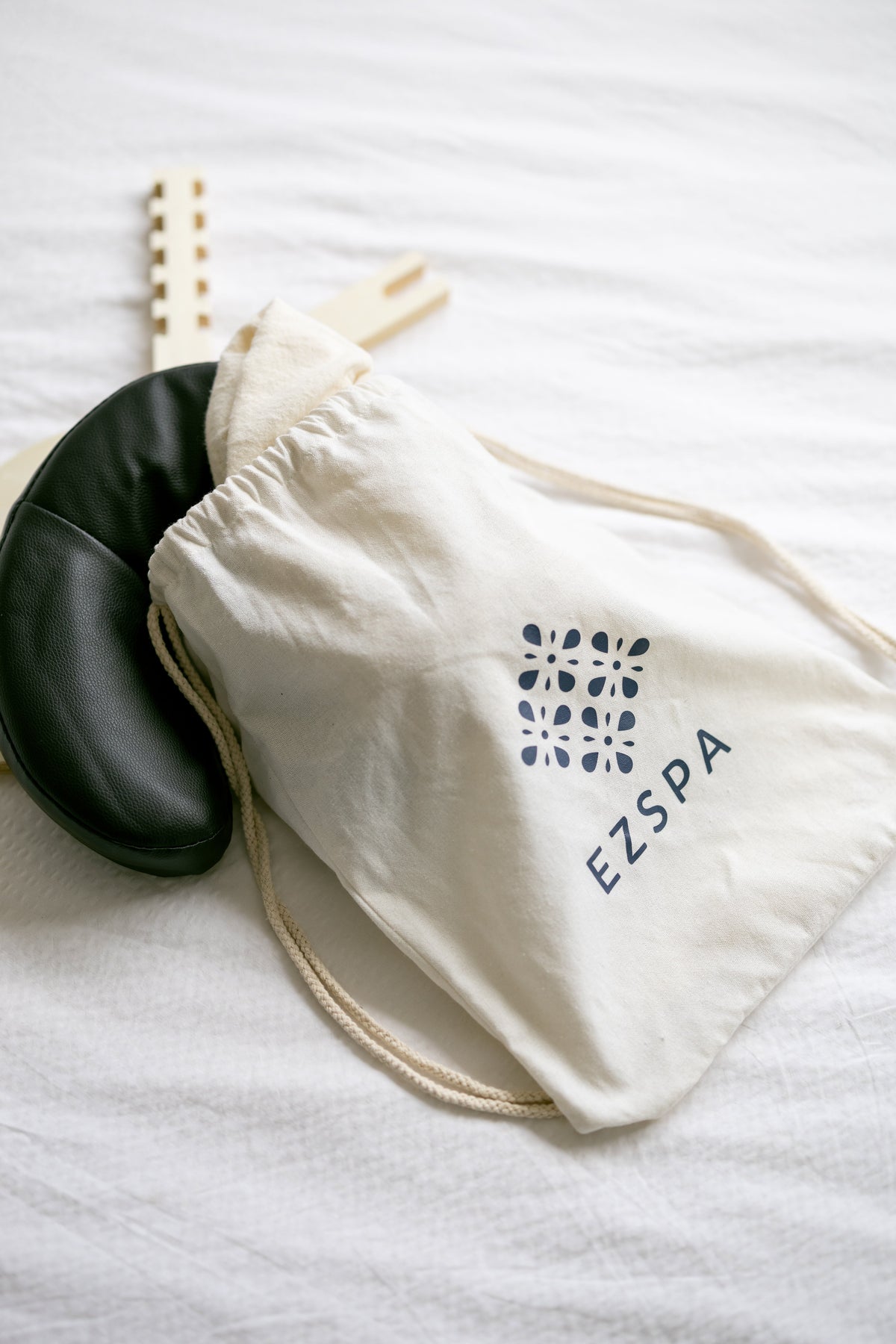The carry bag with the black head cushion and the wooden frame beside it