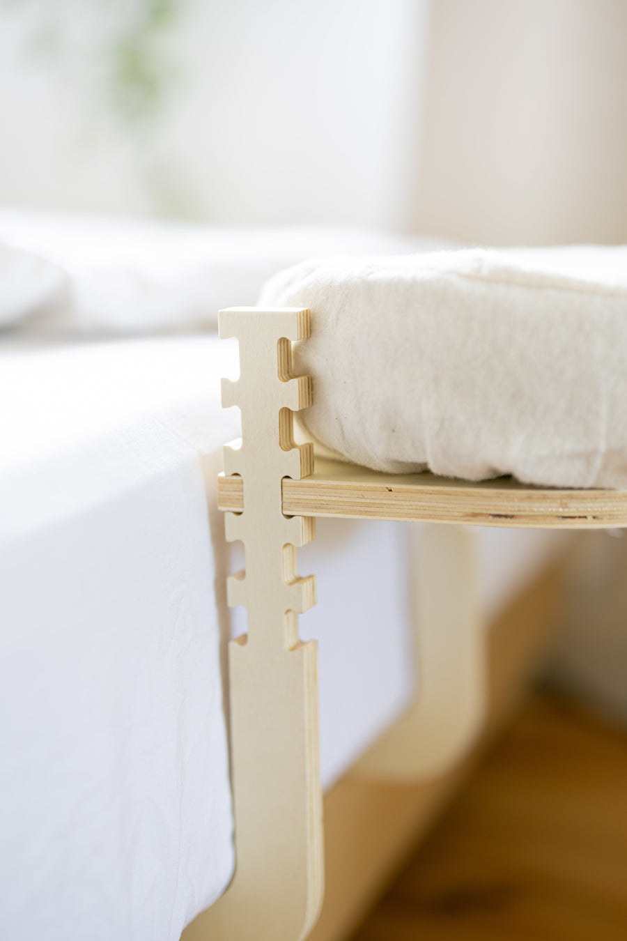 The wooden frame with head cushion from the side, at the edge of a mattress